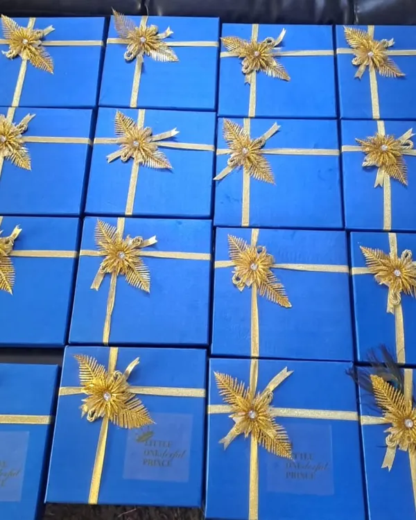 A large order of customized return hampers for a first birthday party. The royal blue boxes with golden ribbons add a touch of elegance to the celebration.