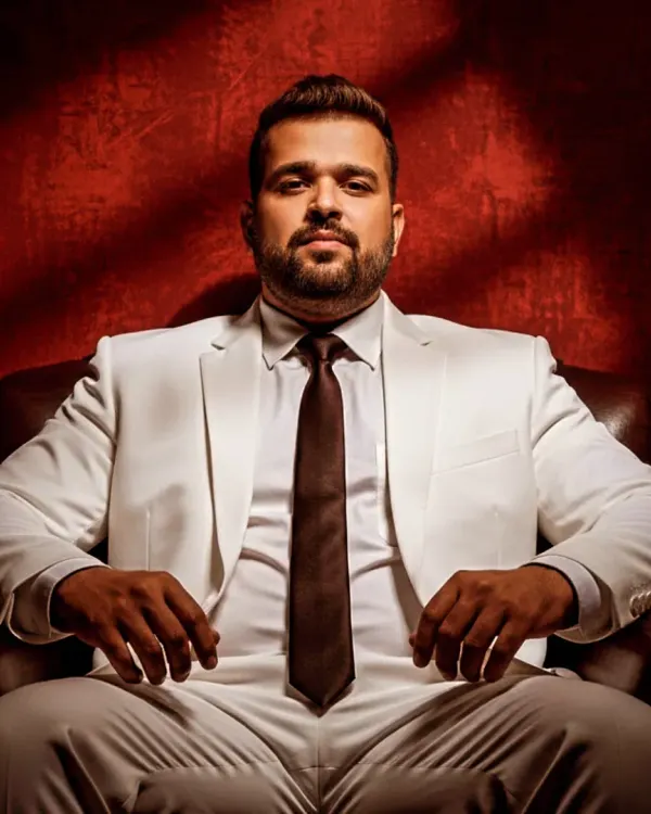 A powerful shot from a digital magazine photoshoot. The classic white suit and dramatic lighting create a timeless look.