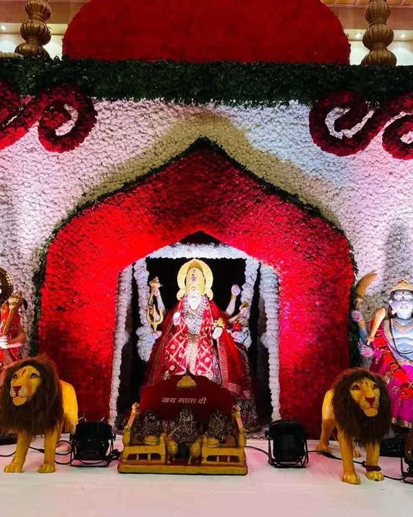 A grand backdrop I created for a Mata ki Chowki. The central arch, made of red and white flowers, perfectly frames the deity's idol, creating a divine throne. The entire setup is designed to be a powerful and beautiful focal point for the prayers.