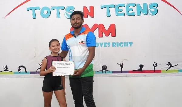 A proud moment. One of our coaches presents a Level 1 certificate to a happy gymnast, celebrating her hard work and achievement.
