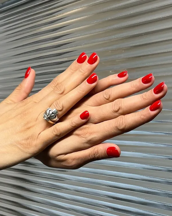 A classic red manicure is always a power move. Here is a set of perfectly shaped, short nails with a vibrant, glossy red gel polish. It’s a timeless look that exudes confidence and style.