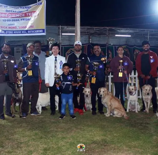 Our entire K9 Gurukul team and our winning dogs posing for a group photo at the 102nd Obedience Dog Show in Ooty. This showcases the variety of breeds we train for competitions.