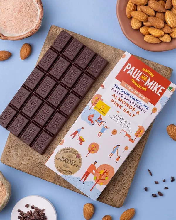 A clean and simple product shot of a dark chocolate bar. I styled it on a wooden board with its key ingredients, almonds and pink salt, to visually communicate its flavour profile to customers.