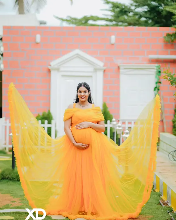 A breathtaking solo portrait with a vibrant yellow gown fanned out to create a stunning visual effect. This shot is all about drama, color, and celebrating motherhood in style.