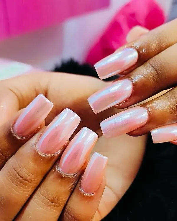 A beautiful and dreamy chrome finish. These long, square-shaped nails have a pearlescent pink chrome powder applied over top, giving them an iridescent shine that shifts in the light.