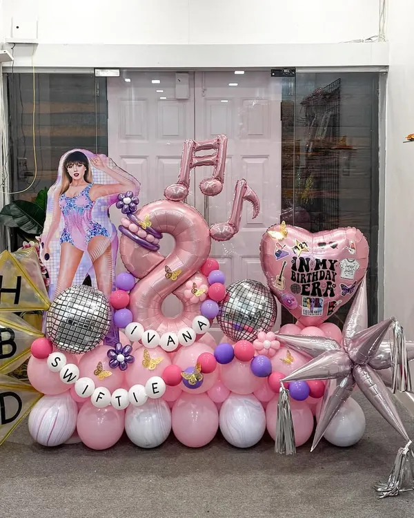 For a true Swiftie's 8th birthday, we designed this Taylor Swift 'Eras' theme. It features a life-size character cutout, musical note balloons, a disco ball accent, and personalized 'HBD' blocks for a complete pop-star party scene.