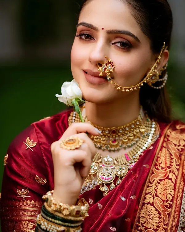 A classic Navari look is all about grace. I created an ultimate soft glam look for this bride, with warm tones on the eyes and a gentle contour to highlight her features, perfectly complementing the rich maroon velvet saree.