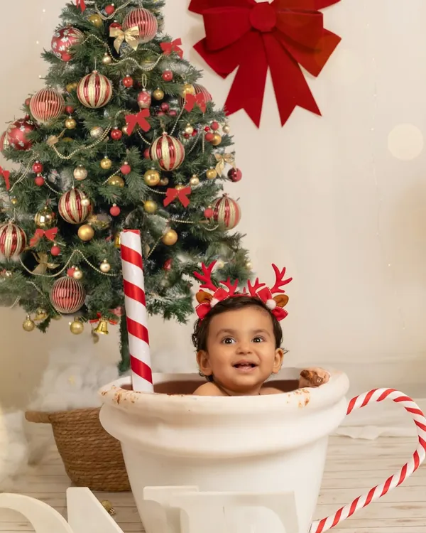 A happy one-year-old enjoys a 'hot chocolate' bath session for Christmas. This creative and fun theme is a sweet way to capture holiday cheer and a major milestone.