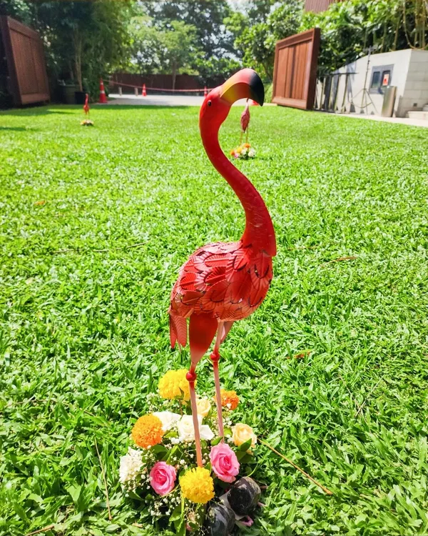 Quirky details like this pink flamingo prop add a fun and memorable touch to a vibrant outdoor Haldi or Mehendi celebration.