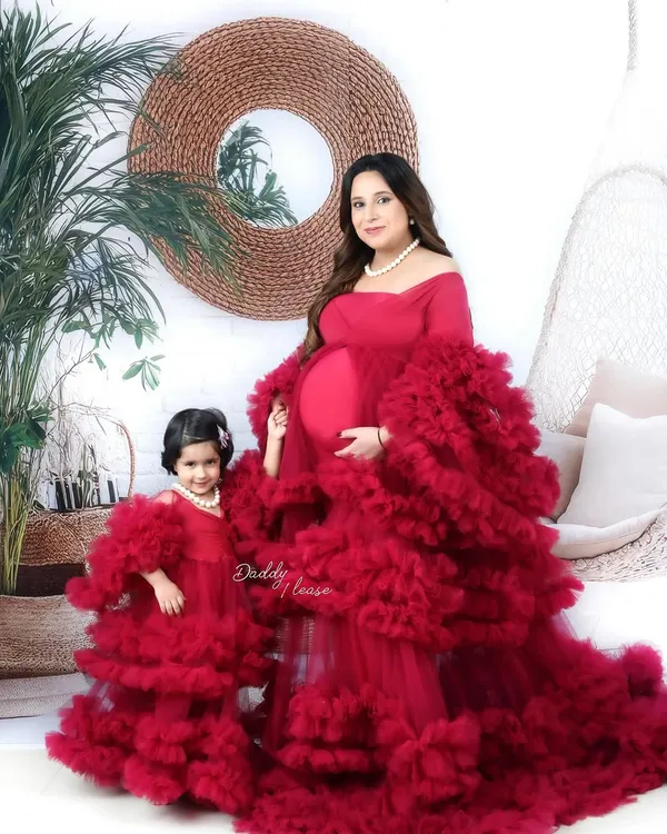A beautiful maternity portrait of a mother and her daughter in matching ruffled red gowns from my luxury outfit collection. I love capturing the bond between family members as they await their new arrival.