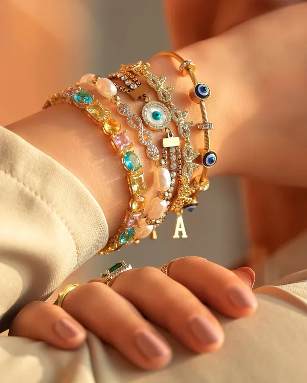 A maximalist wrist stack that is giving everything. This look combines colourful gems, pearls, initial charms, and evil eye bangles for a truly stunning statement.