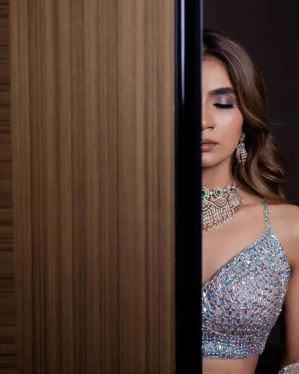 An artistic shot of a glamorous reception look. The focus is on the dramatic smokey eye and contoured cheekbones, creating a high-fashion feel.