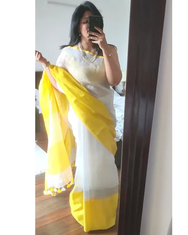 A quick mirror selfie to check my white and yellow linen saree before leaving for lunch. This helps me see the overall drape and how the colours look together.