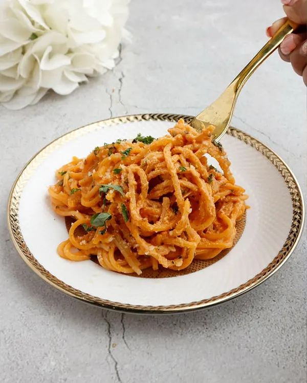 A timeless Italian classic, redefined with elegance. Our Spaghetti Aglio e Olio features delicate pasta strands tossed in golden garlic, olive oil, and a hint of chili, served on exquisite gold-rimmed china.