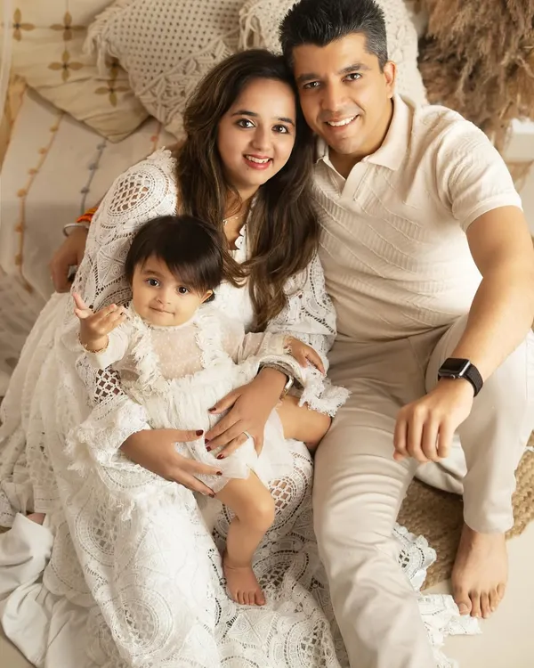 A classic family portrait, seated together in a cozy, boho-inspired studio setting. The coordinated white outfits create a timeless and serene look.