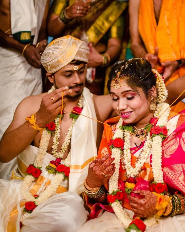A candid moment during the thali tying ceremony. The bride's makeup is designed to be radiant and picture perfect from every angle, with a focus on traditional elements like the bindi and gold jewelry.