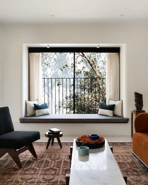 The main goal for this home was to blend it with its natural surroundings. This large bay window in the living room does just that, creating a comfortable seating nook that feels immersed in the trees.