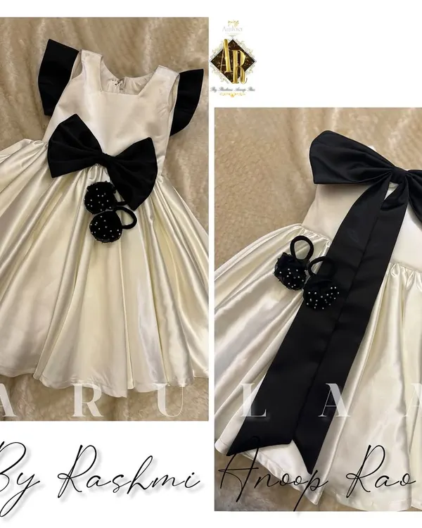 A birthday frock for our cutest client. This ecru satin dress is designed with a big black bow and comes with adorable matching handmade accessories.