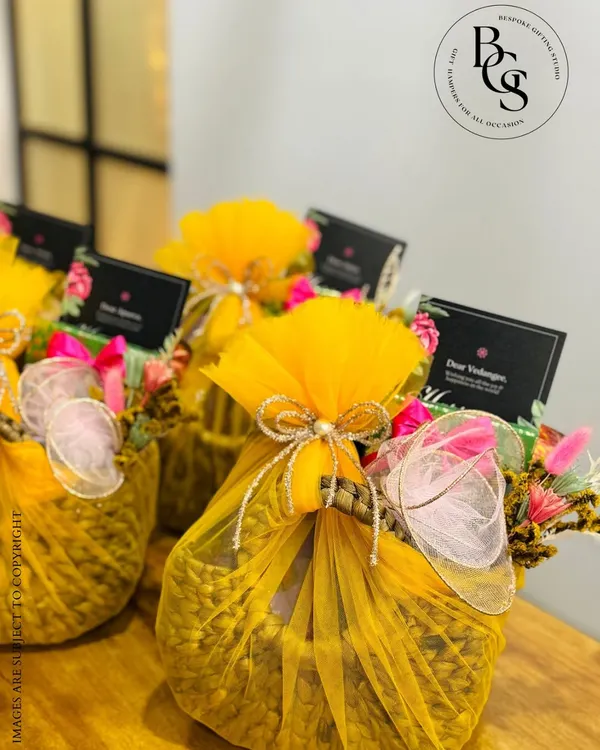 Wrapped in a burst of marigold yellow, these festive hampers are an ode to joy. The woven basket and delicate floral accents make them perfect for adding a touch of luxury and colour to any celebration, from Diwali to a wedding.