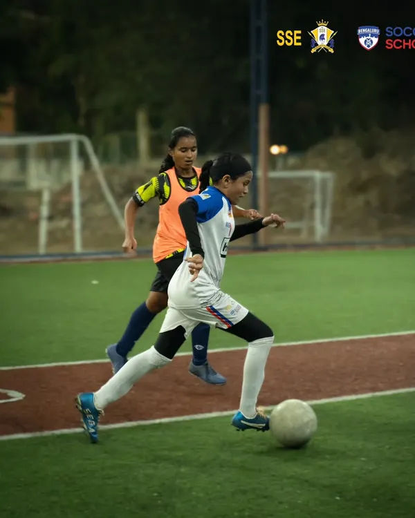 A player skillfully maneuvers the ball while being marked by a defender during a combined training session with Mumbai Knights. This competitive practice sharpens game-day performance.