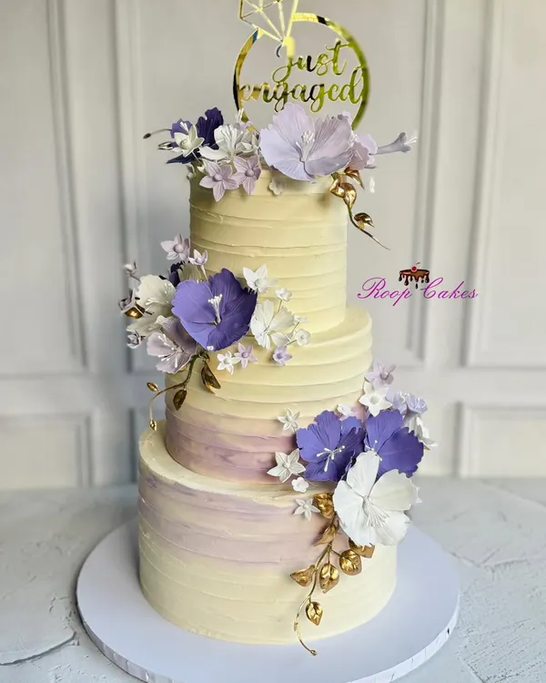This stunning three-tier engagement cake is a true labor of love, adorned with 45 meticulously handcrafted and fully edible purple and white flowers. It's a perfect example of how I can create a grand, memorable centerpiece for your most special occasions.