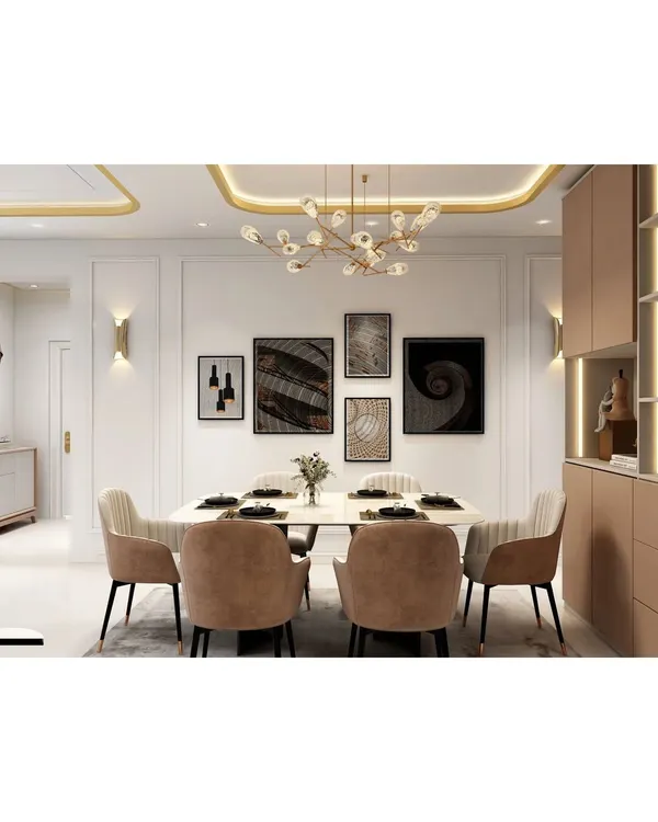 A sophisticated dining area featuring a white marble-top table, plush upholstered chairs, and a modern gallery wall. The cove lighting and statement chandelier add a layer of luxury.