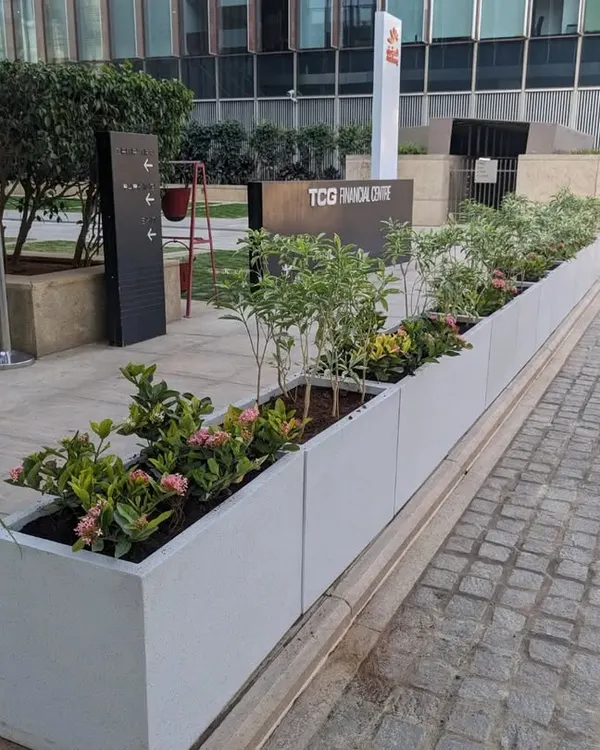 A wide view of the completed installation at the TCG Financial Centre. The row of modern, rectangular FRP planters creates a clean, green border along the building's exterior, enhancing its professional aesthetic.