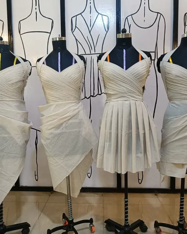 A lineup of student work from our draping class. Each mannequin showcases a different style, from pleated bodices to wrapped skirts, all created with muslin.