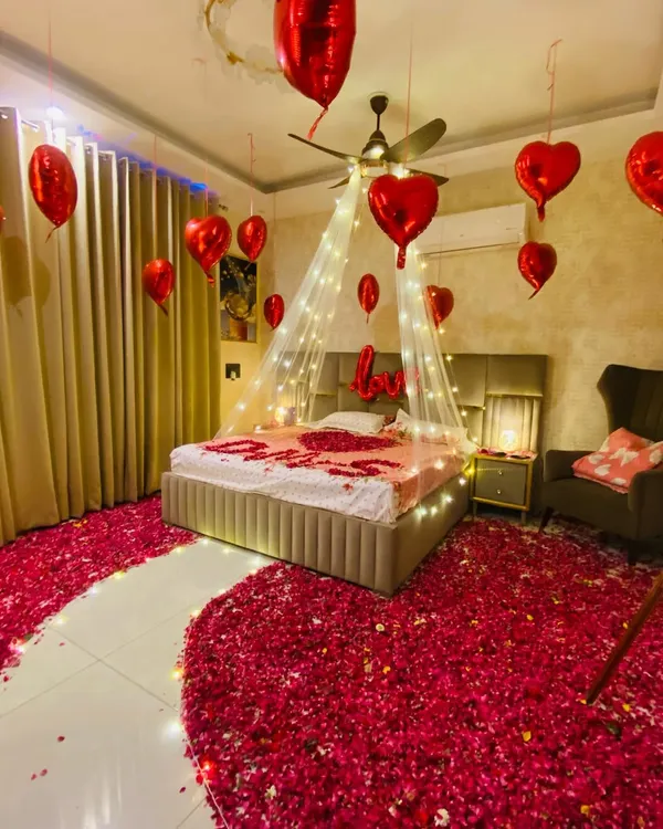 For those truly special occasions, I transform your room into a romantic haven. This setup features a fairy light canopy over the bed, a floor covered in rose petals, and heart-shaped foil balloons to create an unforgettable surprise for your partner.