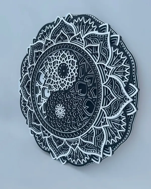 An angled view of our Yin Yang mandala, highlighting the distinct 3D layers that give the piece its sculptural quality. The contrast between black and white is crisp and defined.