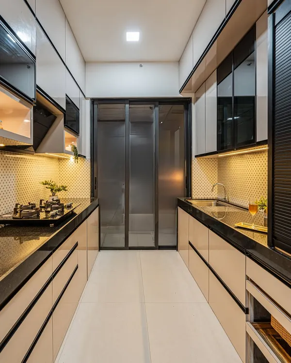 This is a parallel kitchen layout I designed for maximum efficiency. The glossy, handleless cabinets in a dual-tone finish give it a sleek, modern look, while the under-cabinet lighting provides excellent task lighting.