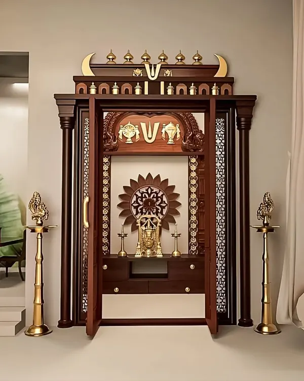 A magnificent, traditional pooja mandir I crafted from dark wood. This freestanding unit features intricate carvings, ornate doors, and brass detailing, creating a truly divine spiritual corner.