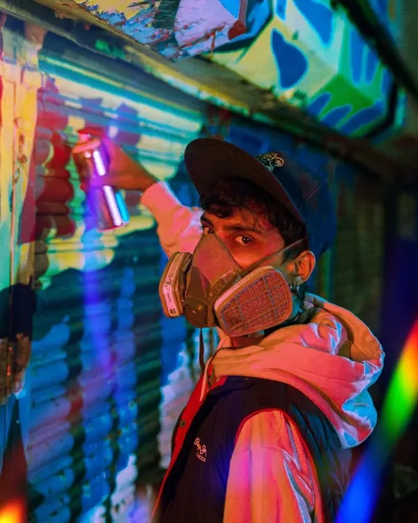 Me in my gear, respirator on, ready to paint. The bright, colorful lighting in this shot captures the energy I feel when I'm about to start a new piece.