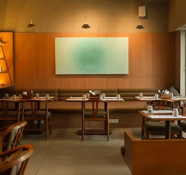 An art installation at Sidewalk cafe in Agra. This minimalist piece with a soft green gradient adds a calming pop of color to the warm, wood-paneled dining room.