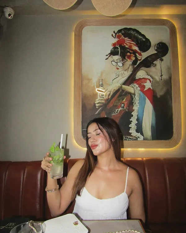 A simple white camisole top, perfect for a relaxed brunch, accessorized with simple jewelry.