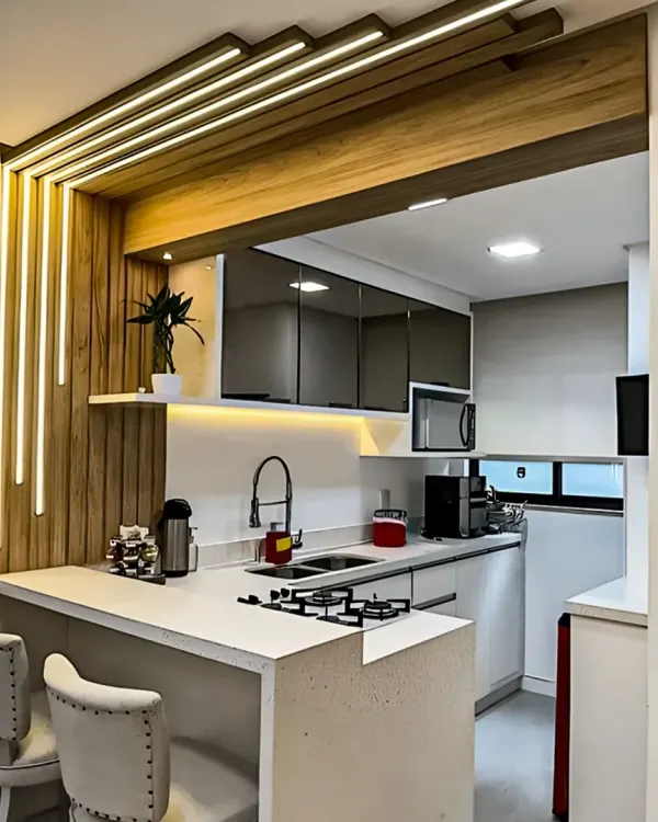 This compact kitchen is enhanced with a stylish breakfast bar, featuring dramatic integrated LED lighting. It's a perfect example of how to add functionality and flair to a smaller space.