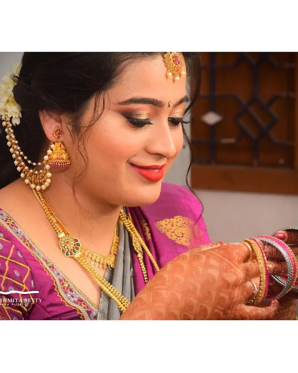 A candid moment of the beautiful bride getting ready. This simple and elegant engagement makeup features a soft smokey eye and a classic red lip that looks stunning with her jewelry.