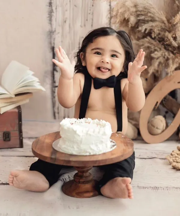 The best part of a cake smash? The pure, unfiltered happiness! This little traveler is enjoying his first taste of birthday cake in our rustic, globe-trotter themed setup.