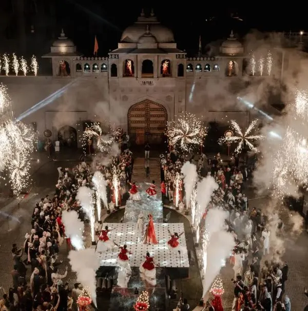 A truly majestic varmala exchange at a grand palace wedding. We specialize in capturing these large scale, breathtaking moments, using techniques like aerial shots to create an unforgettable visual spectacle of your big day.