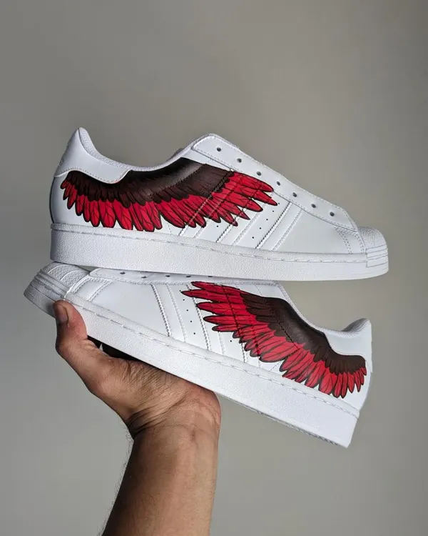 A pair of Adidas Superstars with fiery red wings that I painted live at an Adidas event in Bengaluru.