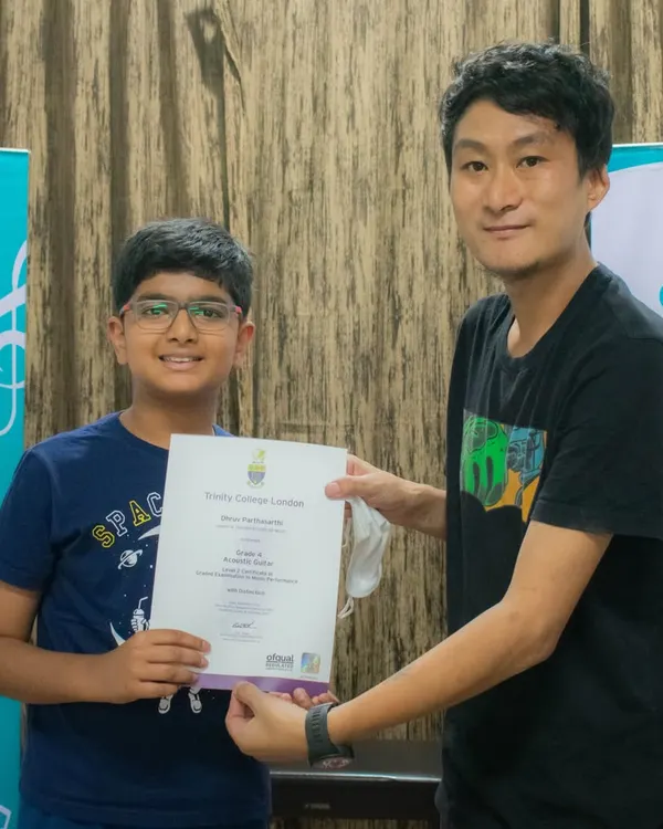 A moment of achievement as our student receives his Trinity College London grade exam certificate. We guide students through the entire certification process.