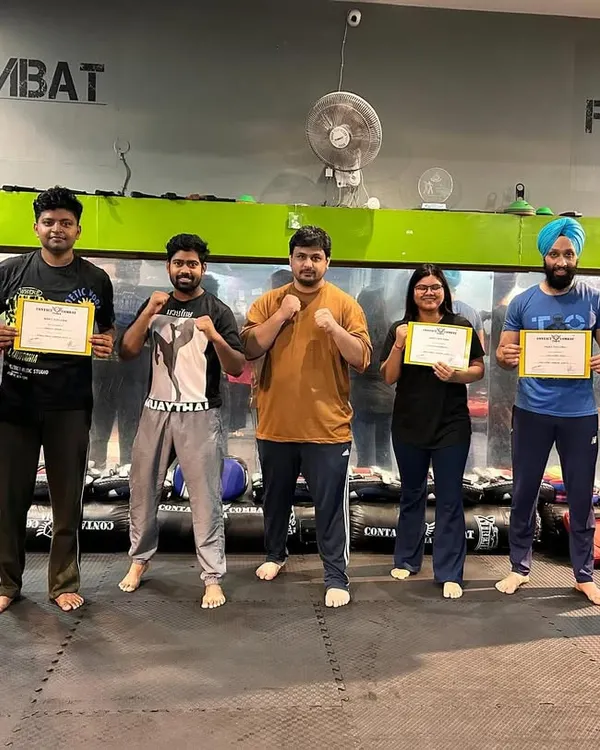 A group of students proudly holding their certificates after successfully passing their level test. Each certificate is earned through sweat, dedication, and a demonstration of practical skill.