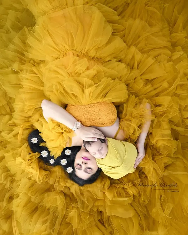 A mother's love is a universe of its own. Here, mom and her newborn are enveloped in a sea of vibrant yellow tulle, a portrait of pure serenity and connection. This artistic overhead shot is one of my favorite ways to capture the bond that defines motherhood.
