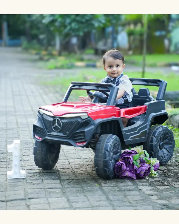 Ready to ride into his first birthday celebration. This little prince looks adorable in a toy jeep, a fun and dynamic prop for a first birthday shoot.