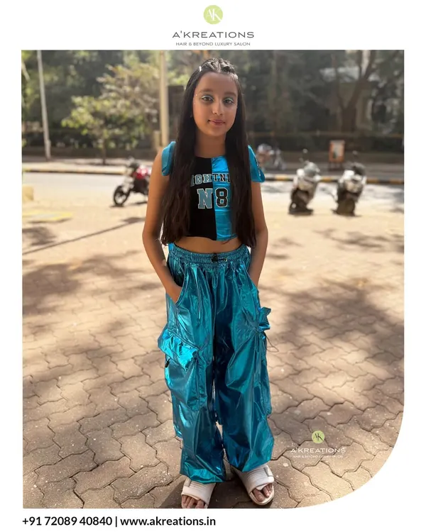 This young client is rocking her full look, with trendy braids, hair tinsel, and subtle face gems for a fun, party-ready style.