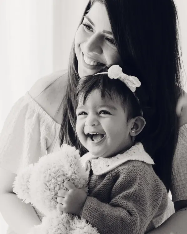 The pure joy between a mother and her child, captured in a classic black and white portrait. Her laugh is absolutely radiant.