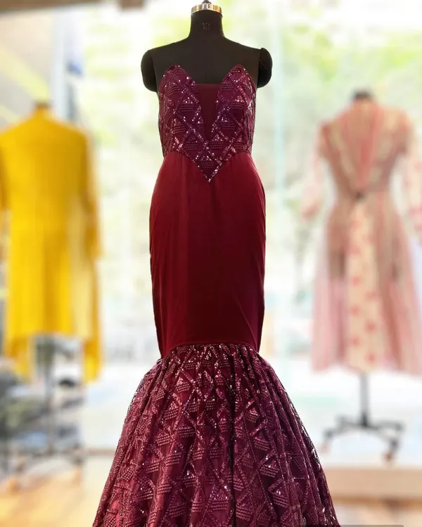 This custom corset bodice ball gown in a deep maroon is pure red carpet glamour. The structured bodice features intricate sequin work, while the mermaid-style skirt adds drama and sophistication.