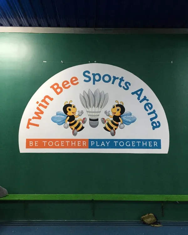 The completed logo mural for 'Twin Bee Sports Arena', a badminton court in Bangalore. We painted their brand identity, including the mascot and tagline, to create a welcoming and professional look for their facility.