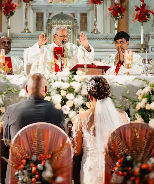 The priest gives his blessing to the couple during a beautiful Catholic wedding ceremony. I position myself to capture the solemnity of the moment and the grandeur of the church.
