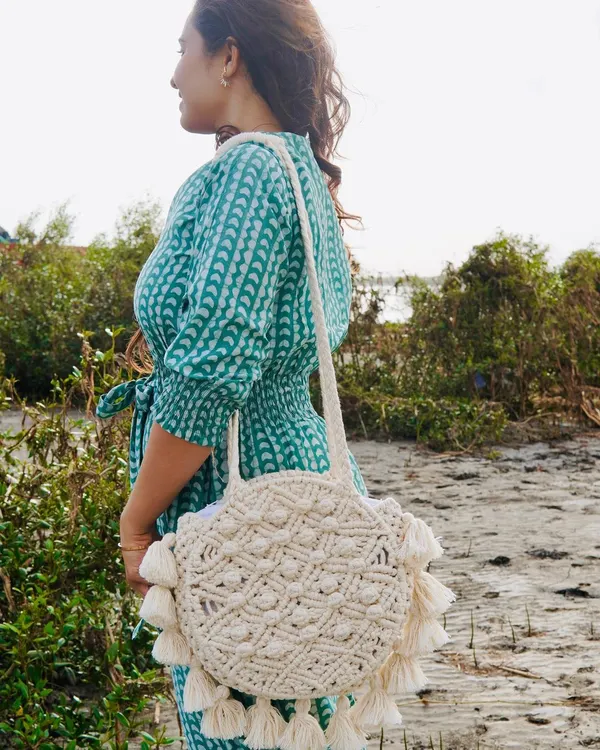 This is my absolute favorite bohemian fringe bag! 🤩 I designed this round macrame purse to be the perfect companion for a beach walk or a brunch date. It's handcrafted from soft, recycled cotton cord, features beautiful knot details, and has super fun tassels all around. It's also surprisingly spacious and comes with an inner lining and a zip to keep your things safe.